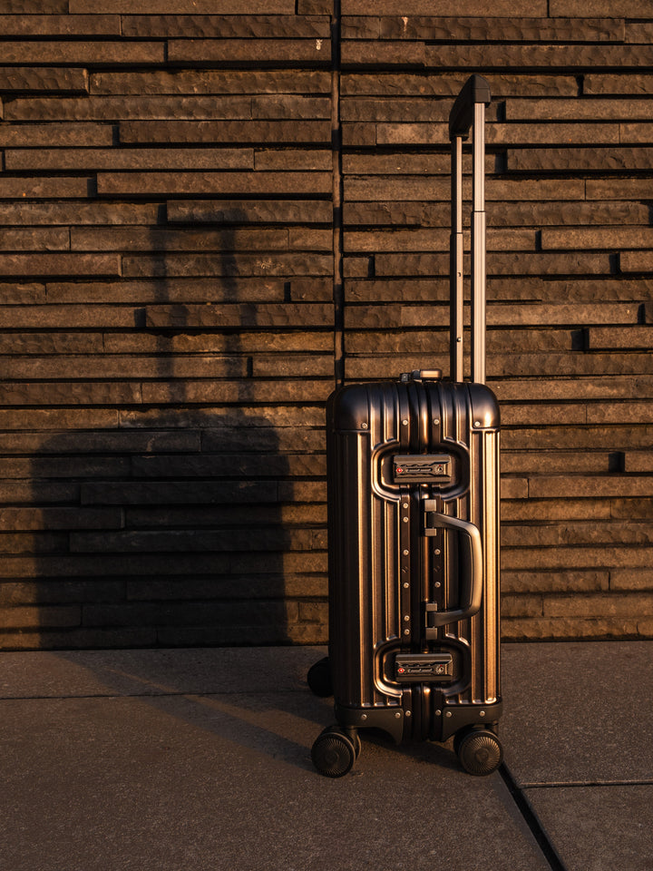 PREZOR suitcase in Metallic Grey with the telescopic handle extended in the evening light