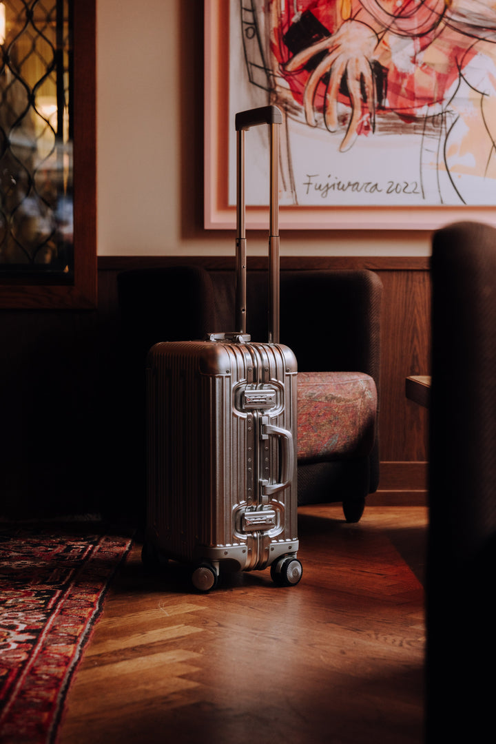 Silver PREZOR suitcase in a hotel lobby